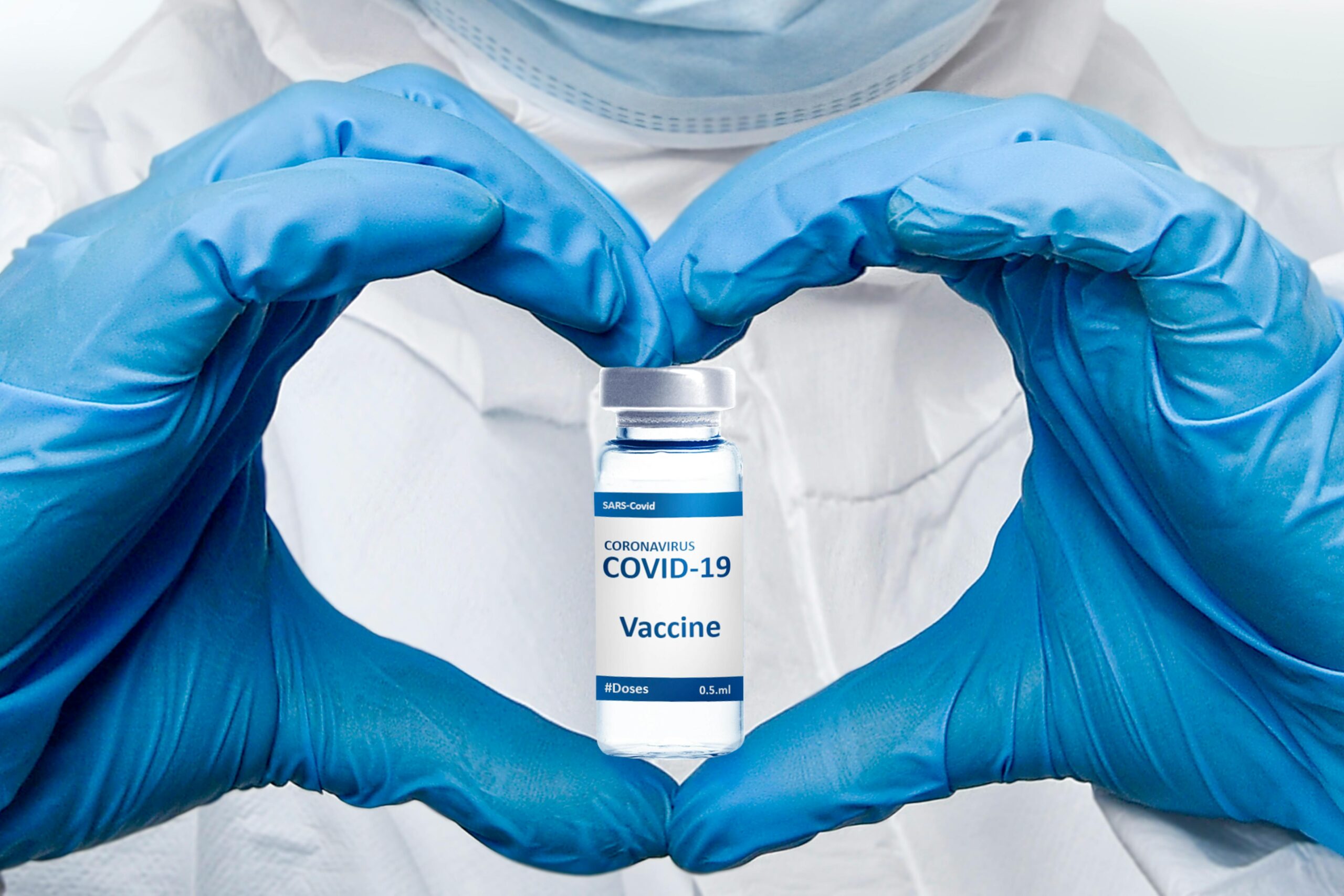 A gloved healthcare professional holds a COVID-19 vaccine vial, emphasizing protection and medical care.